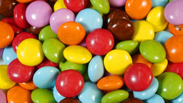 Fargerike sjokoladebelagte godteri i forskjellige nyanser av rød, gul, grønn, blå, lilla, oransje og brun