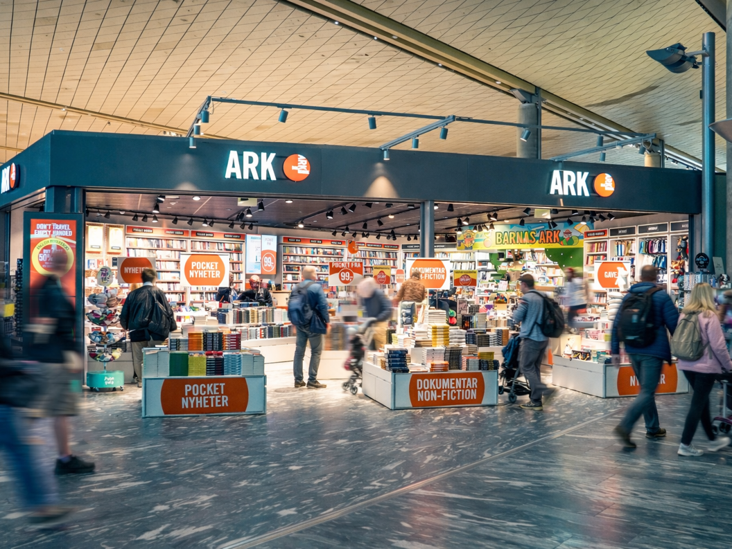 En kvinne som blar i fargerike barnebøker på en grønn bokhylle i en bokhandel, fokusert på å velge en tittel