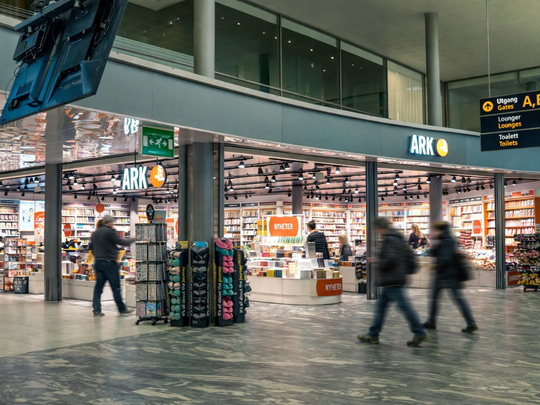 Kvinne ser på barnebøker i en bokhandel. Håndplukking av en bok fra hyllen i avdelingen for aldersgruppen 9-12 år.