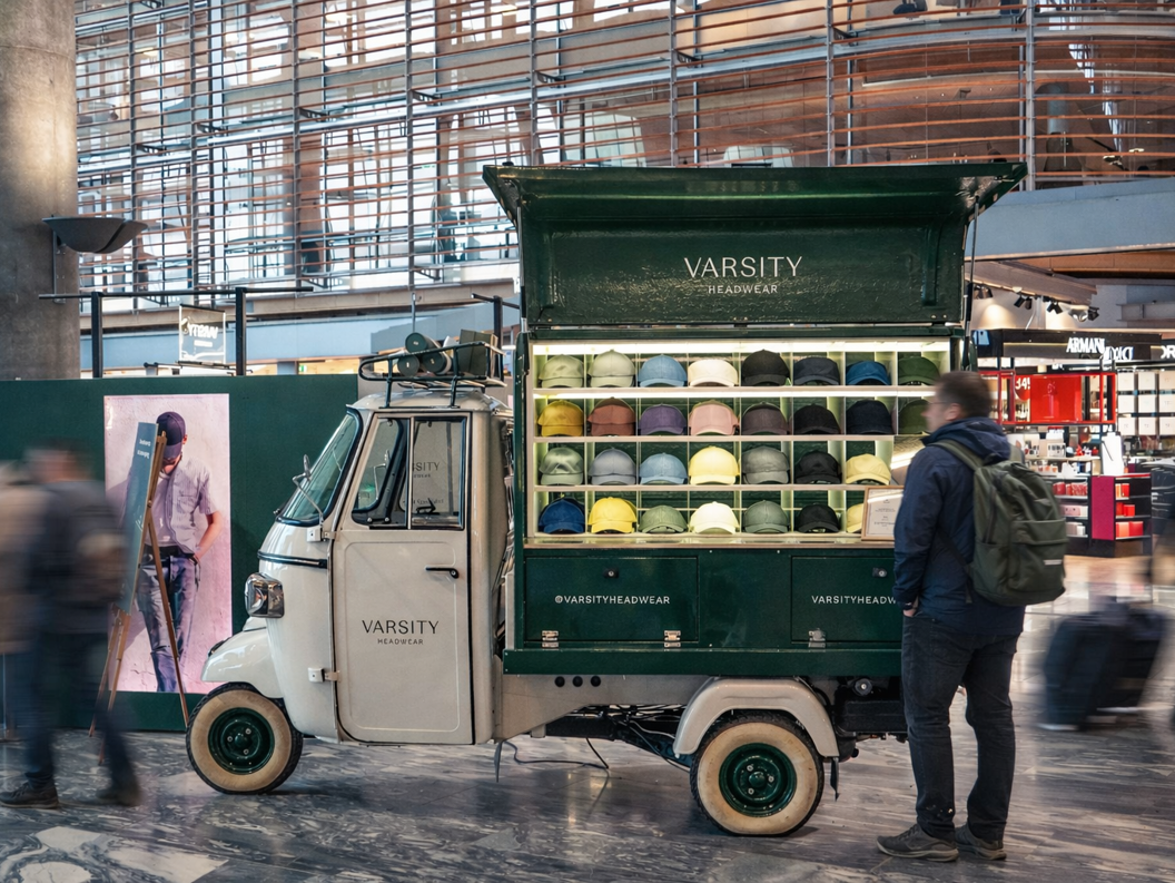 To stilige capser, én grønn og én grå, plassert på stablede hvite betongblokker med en mørk bakgrunn