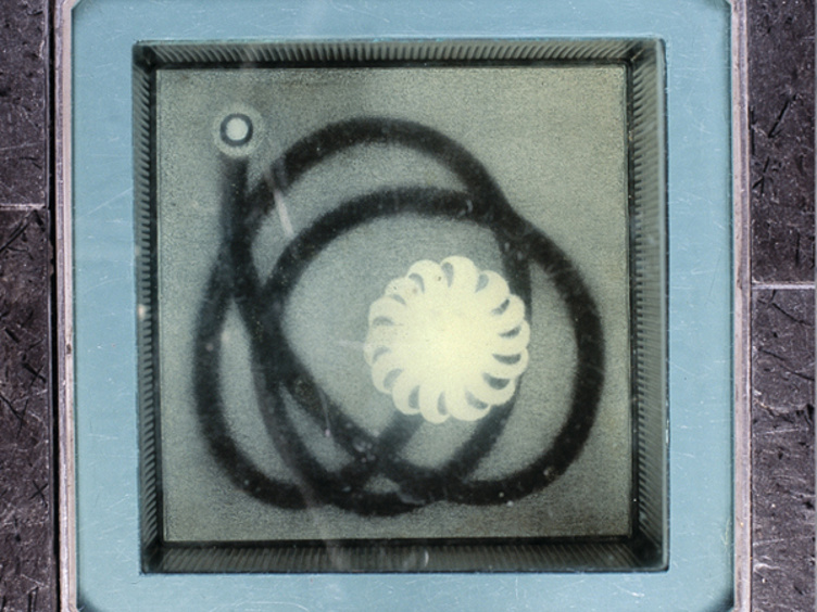 Abstrakt kunstverk bak glass med sirkulære og spiralformer i svart og hvitt