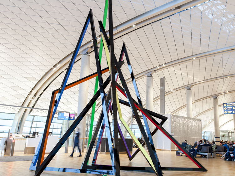 Geometrisk kunstinstallasjon med fargede rammer i en moderne flyplassterminal