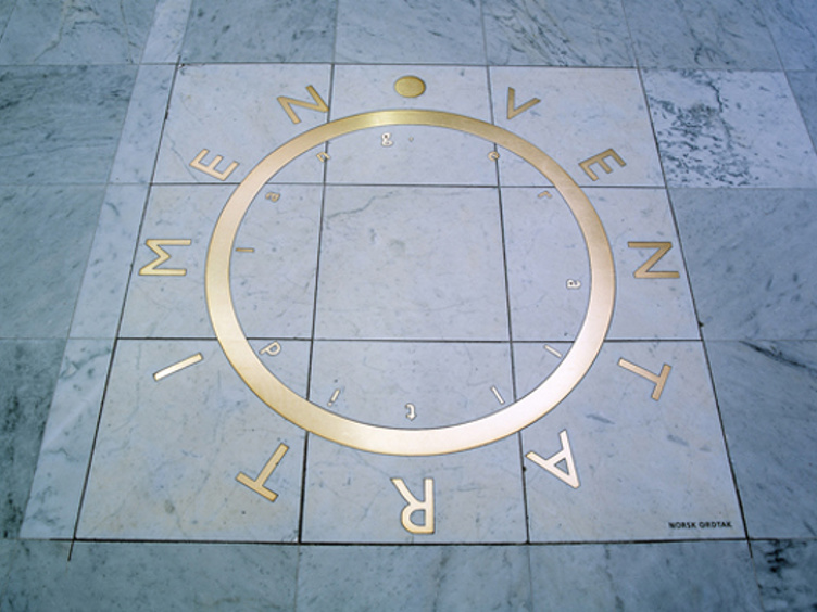 Inne i Vigelandsmausoleet med sirkel av gullbokstaver på marmorgulv