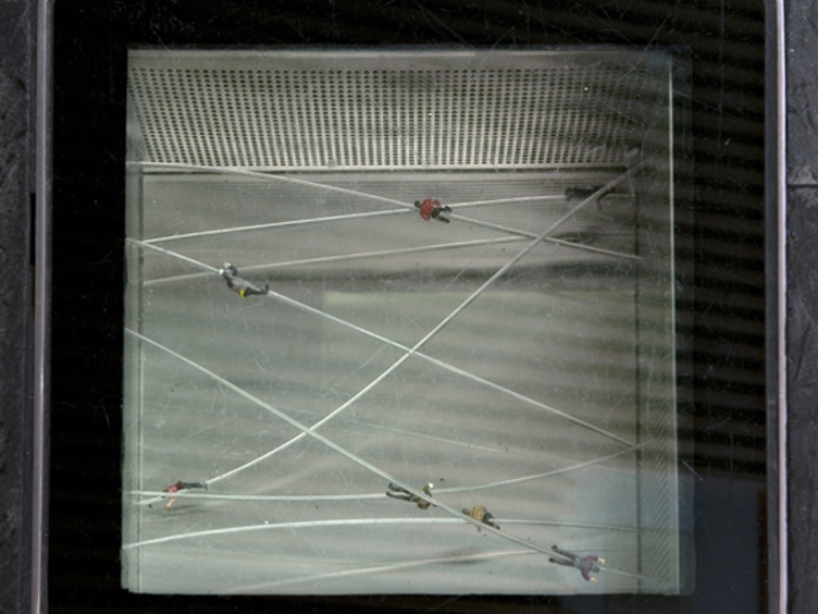 Utsikt av glassboks med små lekerørbiler som kjører på kryssende veier