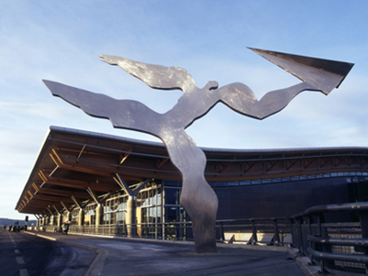 Skulpturen "Uten tittel" foran Oslo lufthavn Gardermoen, med moderne design i metall, mot en blå himmel