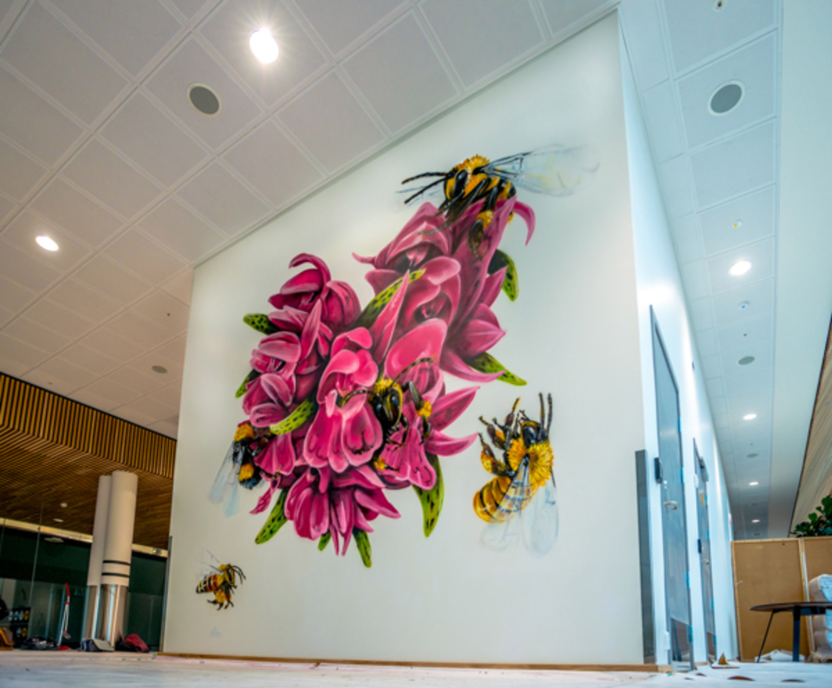 Artwork at Stavanger Airport, a large pink orchid is painted on a wall inside the terminal building